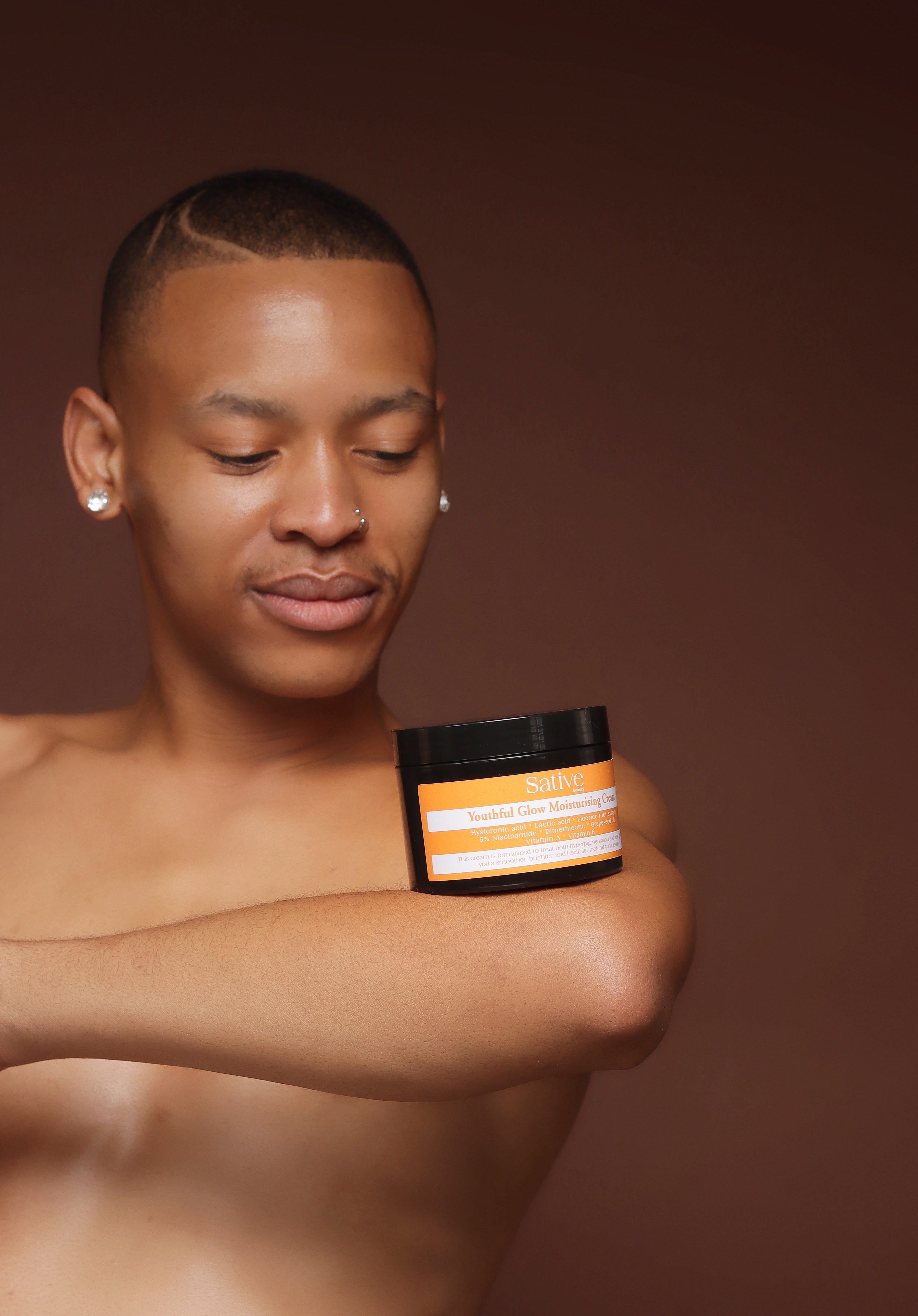 male model posing with skincare product