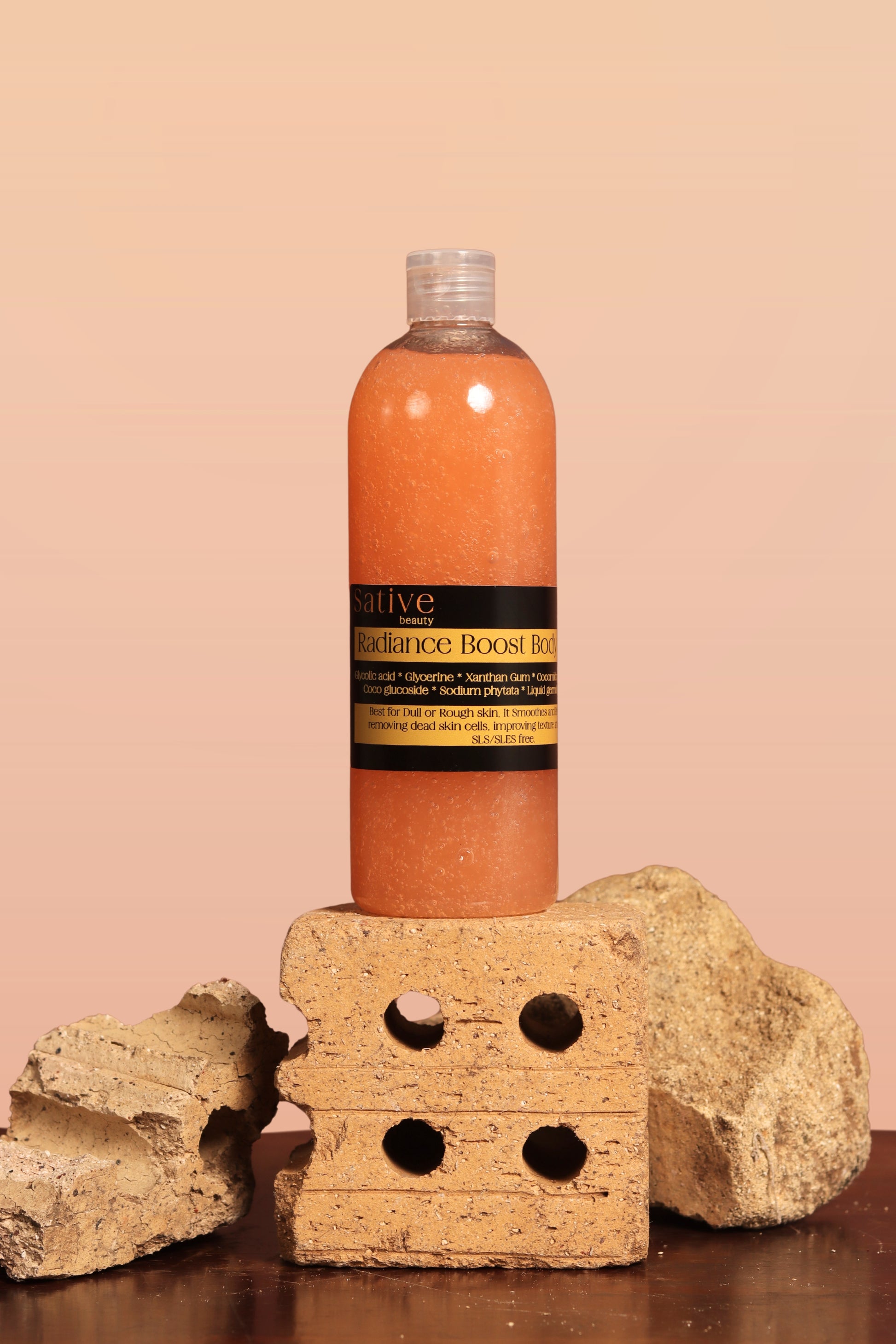 Bottle of Sative Beauty's Radiance Boost Body Wash on a stone block with a beige background