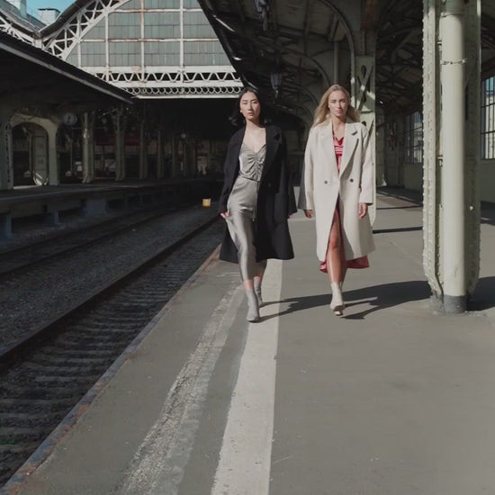 models walking down wearing silk dresses and coats