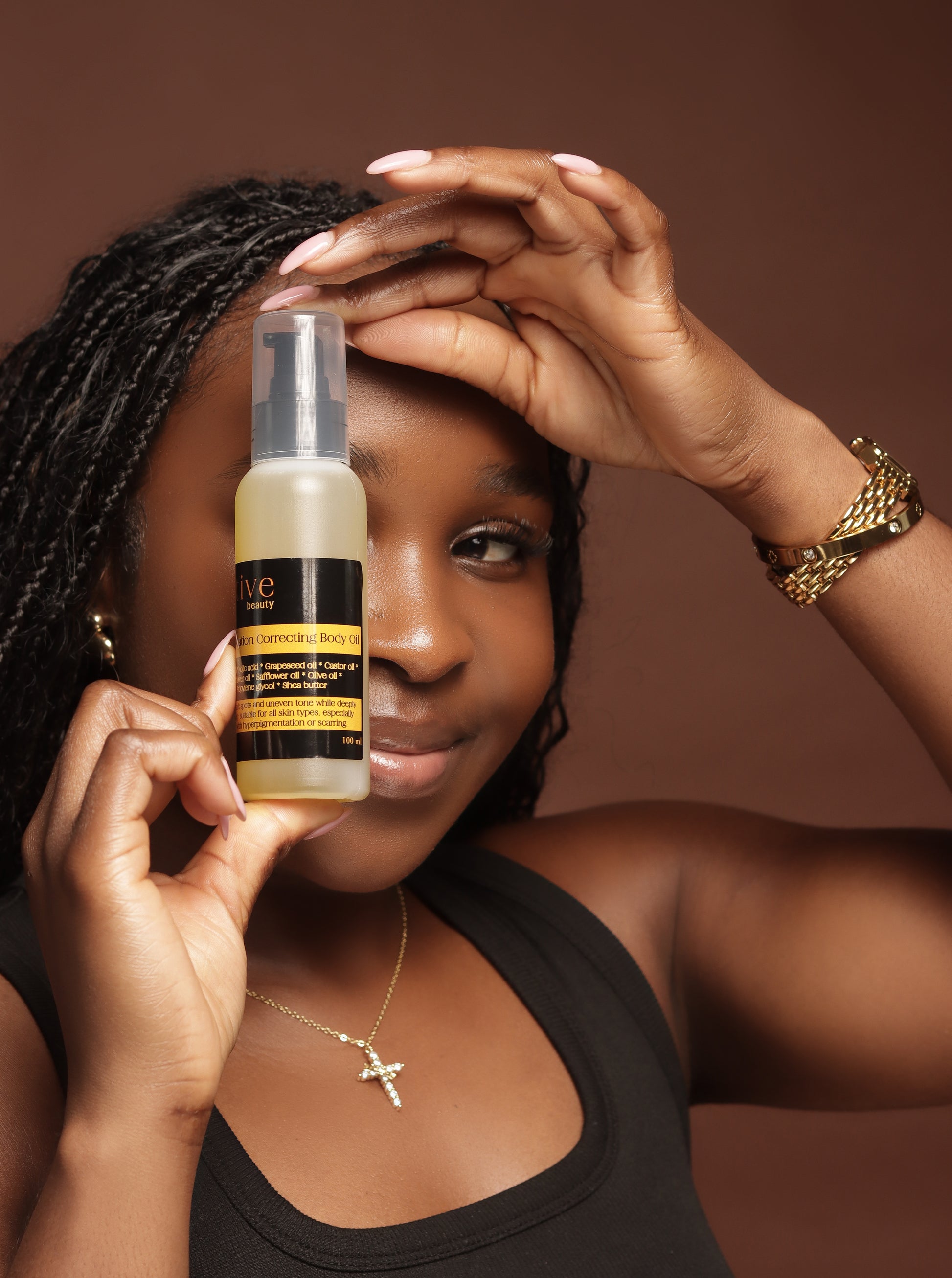 Woman holding a skincare product with a brown background
