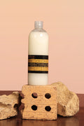 Bottle of Acne Control Body Wash on a stone block with a pink background