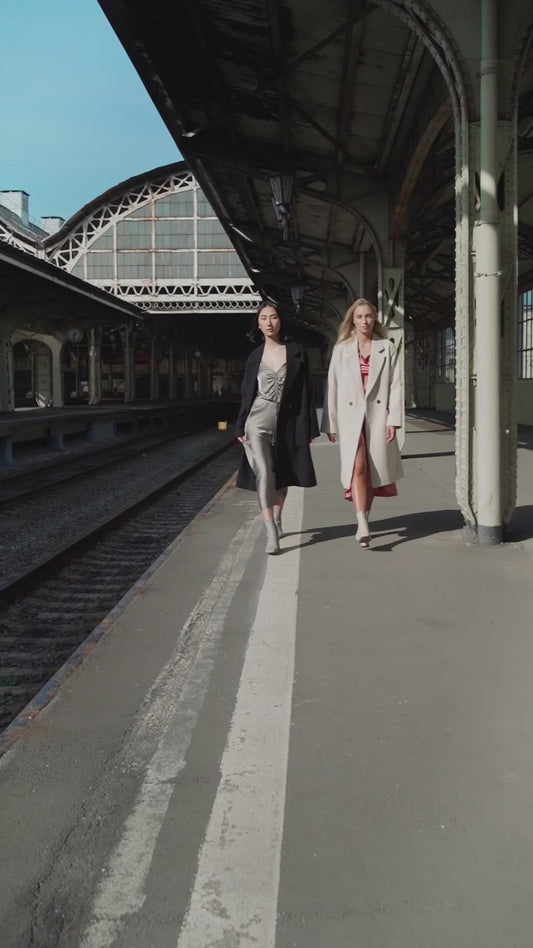 models walking down wearing silk dresses and coats